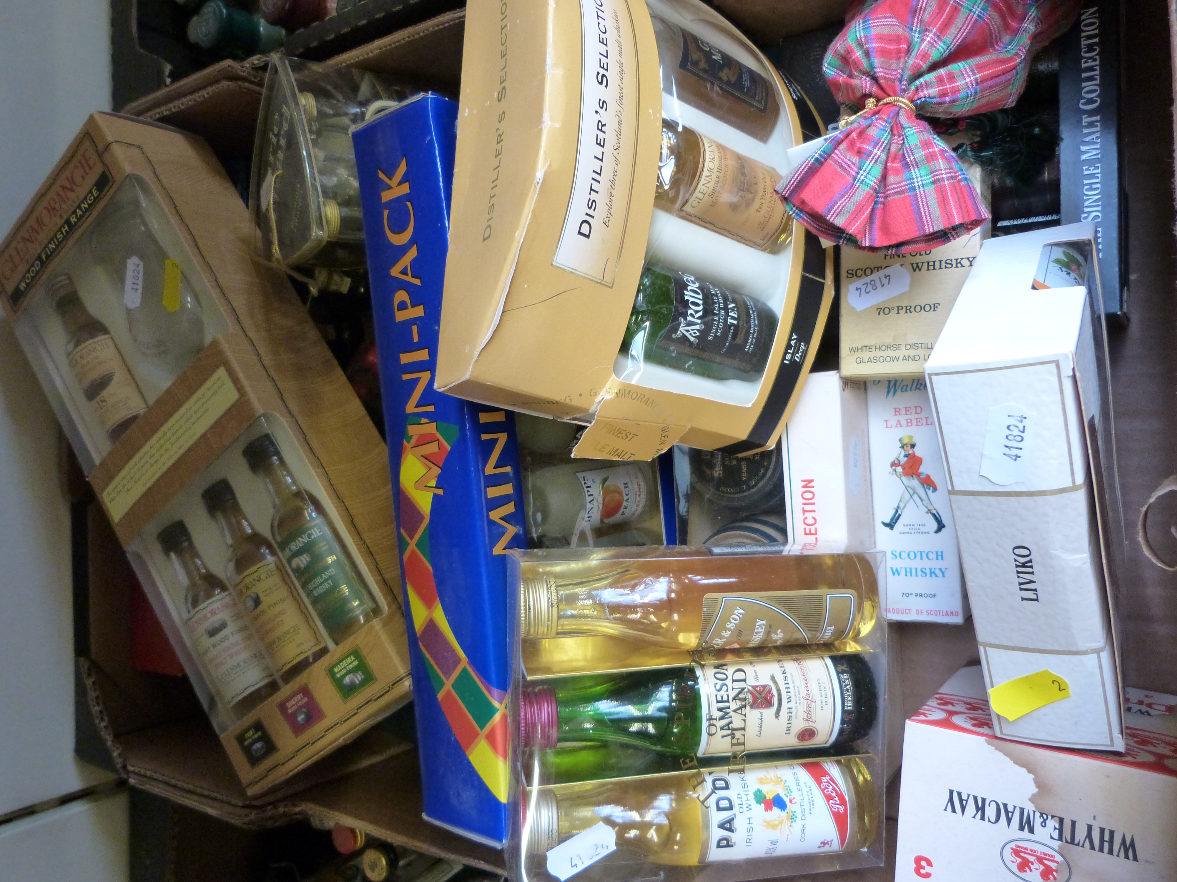 A collection of alcohol miniatures in presentation packs and boxes, including Glenmorangie whisky,