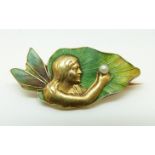 An Art Nouveau 14ct gold brooch depicting a fairy set with green enamel to her wings and holding a