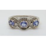 An 18ct white gold ring set with three oval cut tanzanite and diamonds (size N)