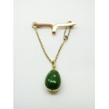 A Faberge 18ct gold and green guilloche enamel egg pendant, on 15ct brooch,