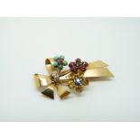 A French 18ct gold brooch set with ruby cabochons, sapphires, turquoise,
