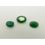 Three apple green oval cut emeralds the largest approximately 0.