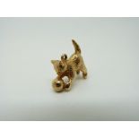 A 9ct gold charm/ pendant in the form of a cat playing with a ball, 6.