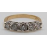 An 18ct gold ring set with five diamonds, the centre diamond approximately 0.