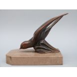A bronze sculpture or car mascot of a swallow or swift mounted on a marble plinth,