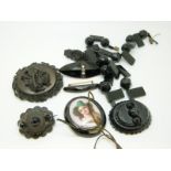 A jet brooch with carved musical instruments, a faceted jet necklace,