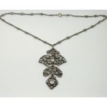 A silver necklace set with paste in a floral design,