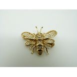 An 18ct gold brooch/ pendant in the form of an insect set with diamonds to the body,