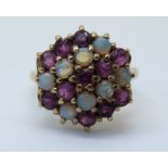 A 9ct gold ring set with rubies and opals in a large cluster (size O)