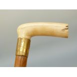 A carved ivory-handled malacca cane with 18ct gold mounts