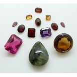 A collection of gemstones including a mixed cut synthetic ruby, an emerald cut purple sapphire,
