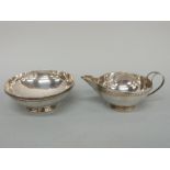 A white metal Arts & Crafts bowl and jug, with hammered decoration and beaded rim,