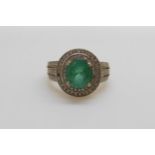 A 14ct gold ring set with an oval cut emerald of approximately 1.