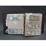 A collection of world bank notes in an album, approximately 180 in all, many uncirculated,