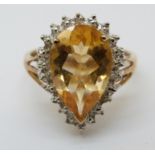 A 9ct gold ring set with a pear cut citrine surrounded by diamonds (size M/N)