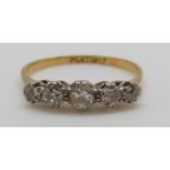 An 18ct gold ring set with five diamonds in a platinum setting, largest diamond approximately 0.