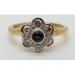 An 18ct gold ring set with a sapphire surrounded by diamonds in a daisy cluster (size O)
