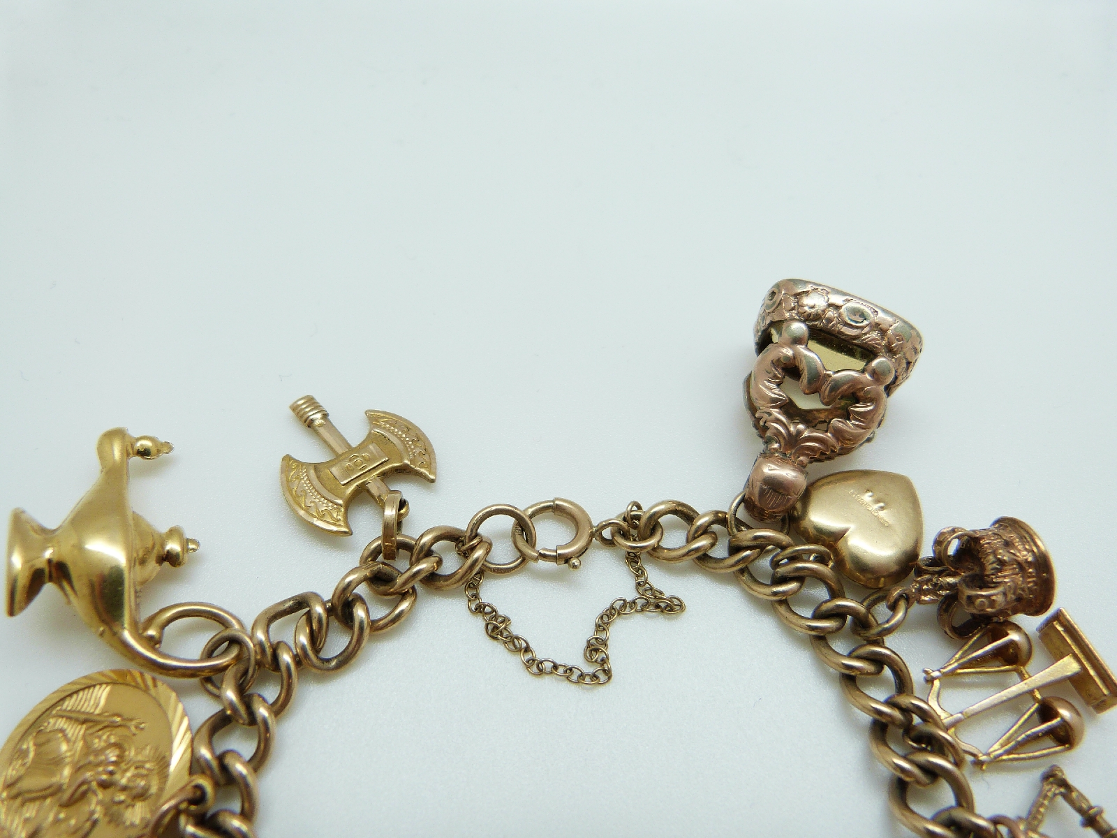 A 9ct gold charm bracelet with eleven 9ct gold charms including a crown, St Christopher, purse, - Image 4 of 8