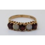 A 9ct gold ring set with garnets and opals (size I)