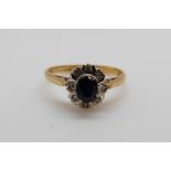 An 18ct gold ring set with a sapphire surrounded by diamonds (size K)