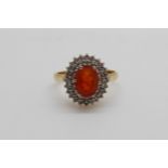 An 18ct gold ring set with a fire opal surrounded by diamonds (size J)