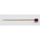 A yellow metal stick pin set with an oval ruby measuring approx 1ct,