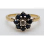 An 18ct gold ring set with a diamond surrounded by sapphires (size K)