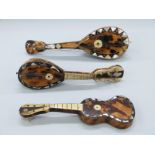 Three tortoiseshell and mother of pearl mandolins/guitars