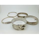 Five silver bangles including a Victorian buckle bangle