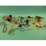 A collection of costume jewellery including beads, brooches,