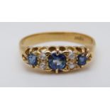 An 18ct gold ring set with three sapphires the largest approximately 0.