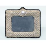 A modern easel back hallmarked silver embossed photograph frame to suit 6x4" photo,