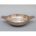A hallmarked silver shallow porringer with pierced handles,