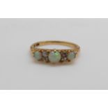 An 18ct gold ring set with three opal cabochons and four old cut diamonds (size N)