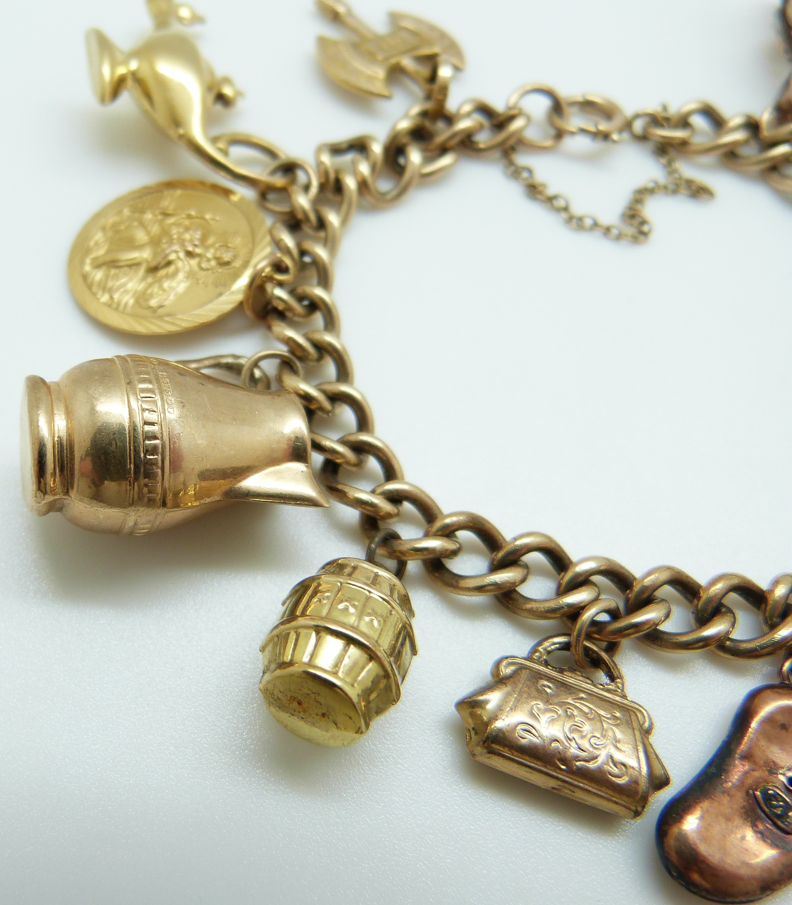 A 9ct gold charm bracelet with eleven 9ct gold charms including a crown, St Christopher, purse, - Image 8 of 8