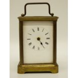 An early 20thC brass carriage clock in corniche style case, enamelled Roman dial,