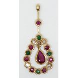 A yellow metal pendant set with a pear cut ruby surmounted by emeralds, diamonds and rubies.