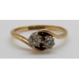 An 18ct gold ring set with two diamonds in a twist setting,