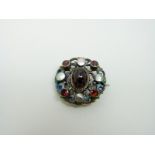 An Austro-Hungarian silver brooch set with a large garnet cabochon to the centre surrounded by blue