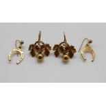 A pair of yellow metal horseshoe earrings and a pair of yellow metal earrings in the form of leaves,