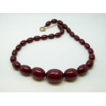 A cherry amber necklace of 29 graduated ovoid beads, the largest approximately 16x22mm, 26g,