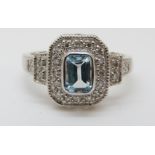 A 9ct gold ring set with a topaz surrounded by diamonds in a rectangular setting (size M)