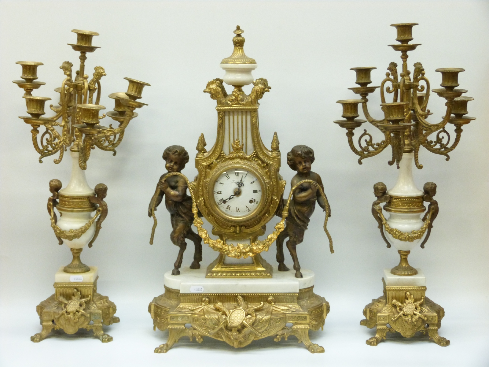 An ormolu and marble French style clock garniture, the German movement striking on a gong,