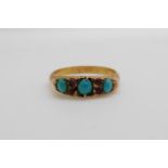 A hallmarked 9ct gold ring set with three turquoise cabochon and four rubies Birmingham 1910 (size