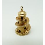 A 9ct gold charm/ pendant in the form of a helter skelter opening to reveal a girl with a mat, 4.
