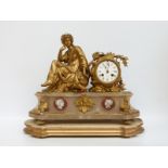 A 19thC ormolu and marble mantel clock with seated Romanesque female figure to one side, and lyre,