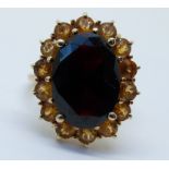 A 9ct gold ring set with a garnet surrounded by quartz (size J)