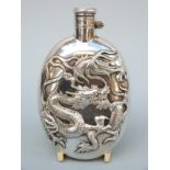 A Chinese white metal hip flask decorated with a dragon and having a bayonet cap,
