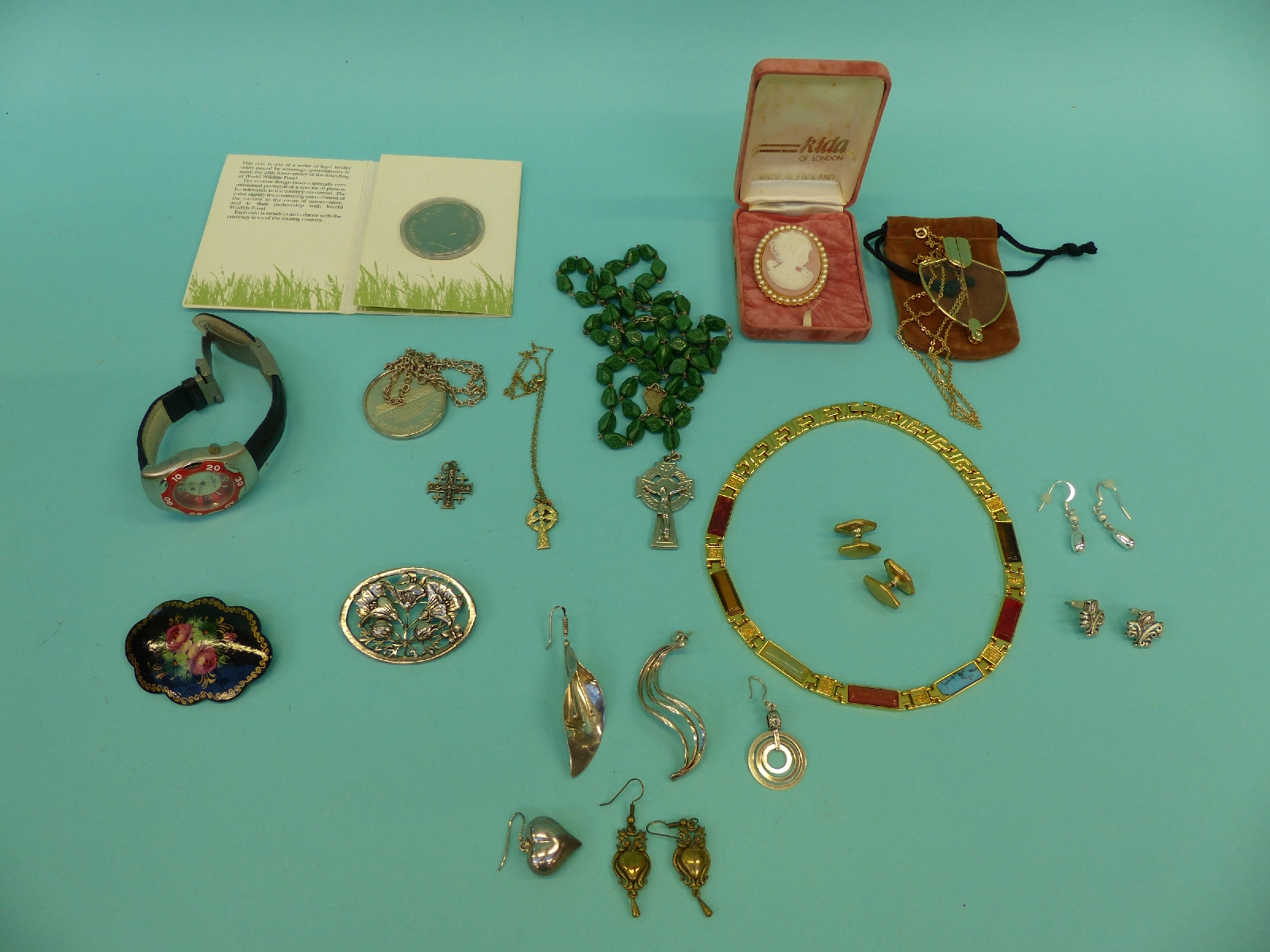 A collection of costume jewellery including a lacquer brooch, silver earrings,