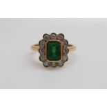 An 18ct gold ring set with an emerald cut emerald of approximately 1ct surround by diamonds (size
